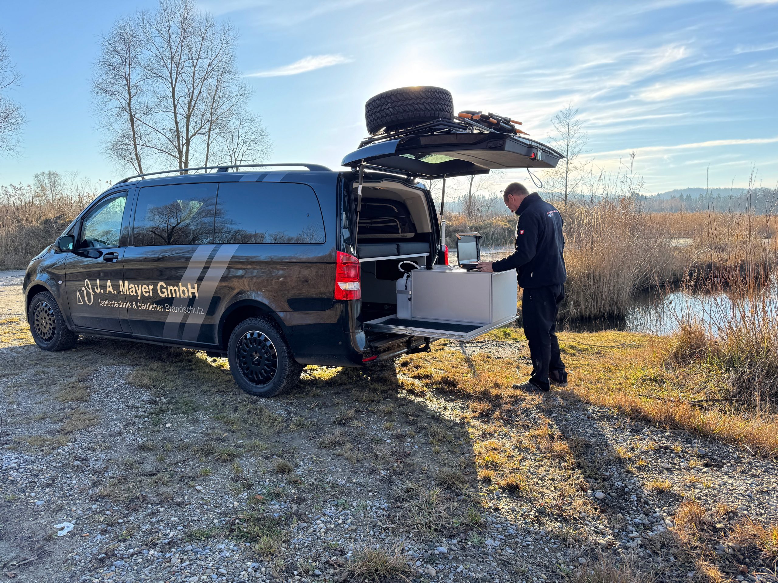 Mercedes Vito Camper Ausbau mit geöffneter Heckklappe und mobiler Küche am See