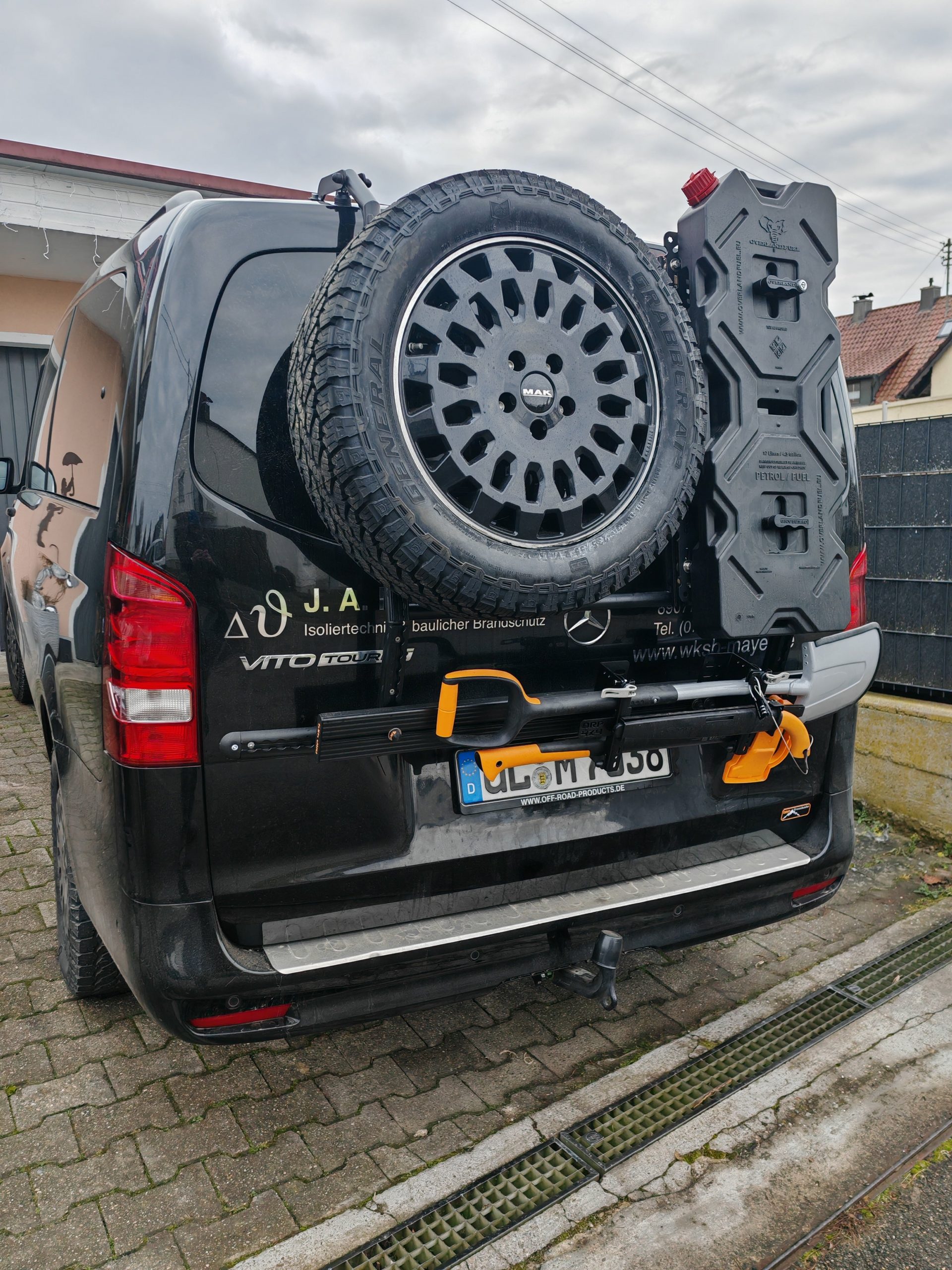 Heckansicht des Vito mit montiertem Ersatzrad, Overland Fuel Kanister und ORP4x4 Fiskars Tool Carrier, zeigt funktionale Außenausstattung.